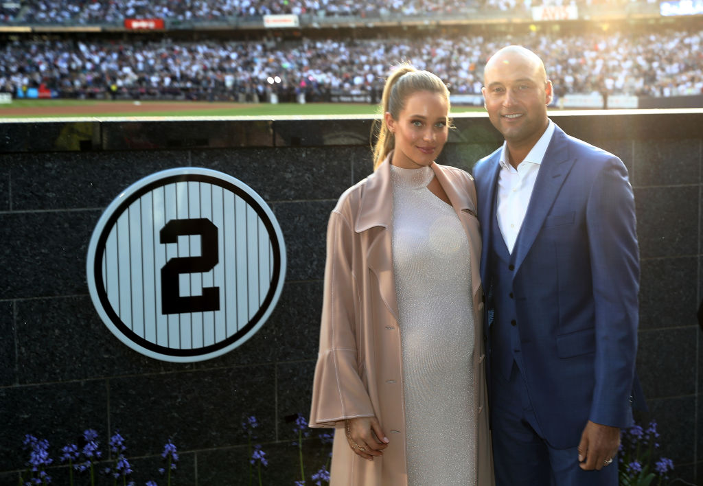 NEW YORK, NY - MAY 14: Former New York Yankees captain Derek Jeter and his wife Hannah Jeter pose next to his number in Monument Park during the retirement cerremony of Jeter's jersey #2 at Yankee Stadium on May 14, 2017 in the Bronx borough of New York City.