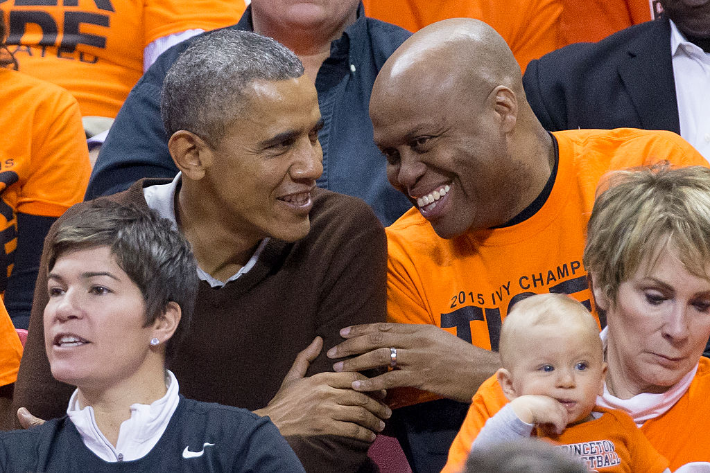 COLLEGE PARK, MD - MARCH 21: (AFP OUT) U.S. President Barack Obama (L) sits beside his brother-in-law Craig Robinson while attending the Green Bay versus Princeton women's college basketball game in the first round of the NCAA tournament, March 21, 2015 in College Park, Maryland. President Barack Obama's niece Leslie Robinson plays for Princeton. 