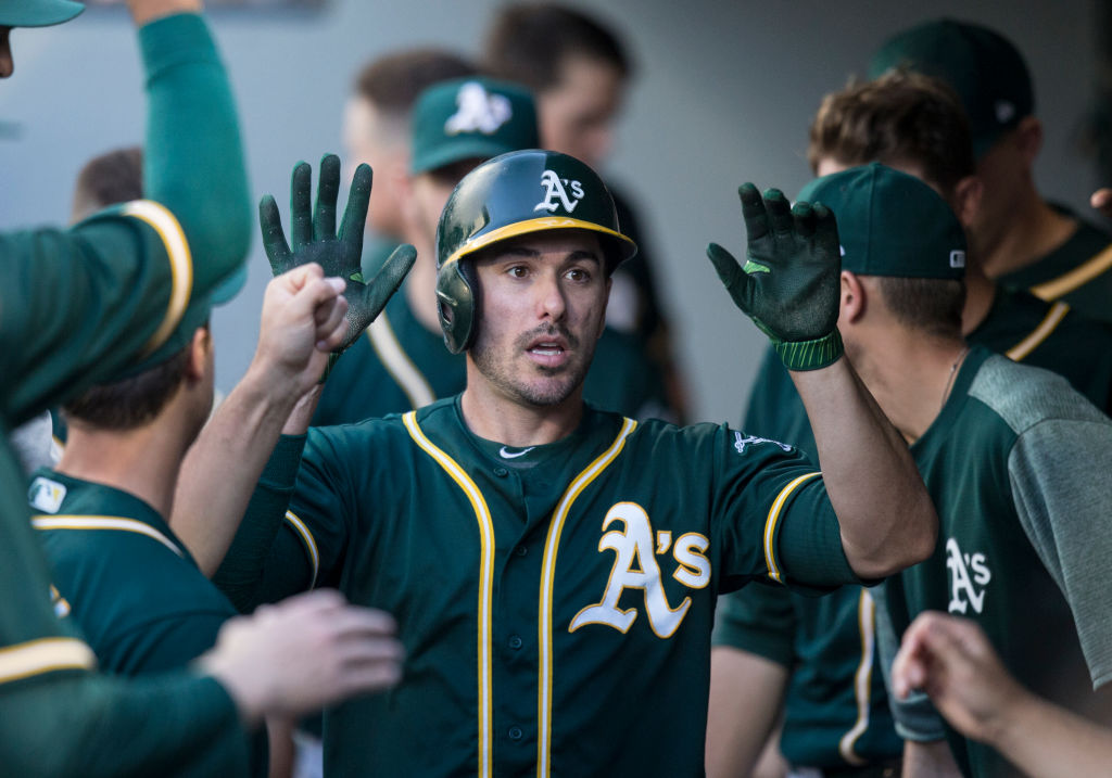 SEATTLE, WA - JULY 6: Matt Joyce #23 of the Oakland Athletics is congratulated by teammates in the dugout after scoring a run on a double by Yonder Alonso #17 of the Oakland Athletics off of starting pitcher Sam Gaviglio #44 of the Seattle Mariners during the first inning of a game at Safeco Field on July 6, 2017 in Seattle, Washington.