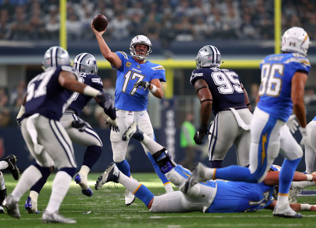 ARLINGTON, TX - NOVEMBER 23: Philip Rivers #17 of the Los Angeles Chargers passes under pressure from DeMarcus Lawrence #90 of the Dallas Cowboys and David Irving #95 of the Dallas Cowboys in the first half of a football game at AT&T Stadium on November 23, 2017 in Arlington, Texas