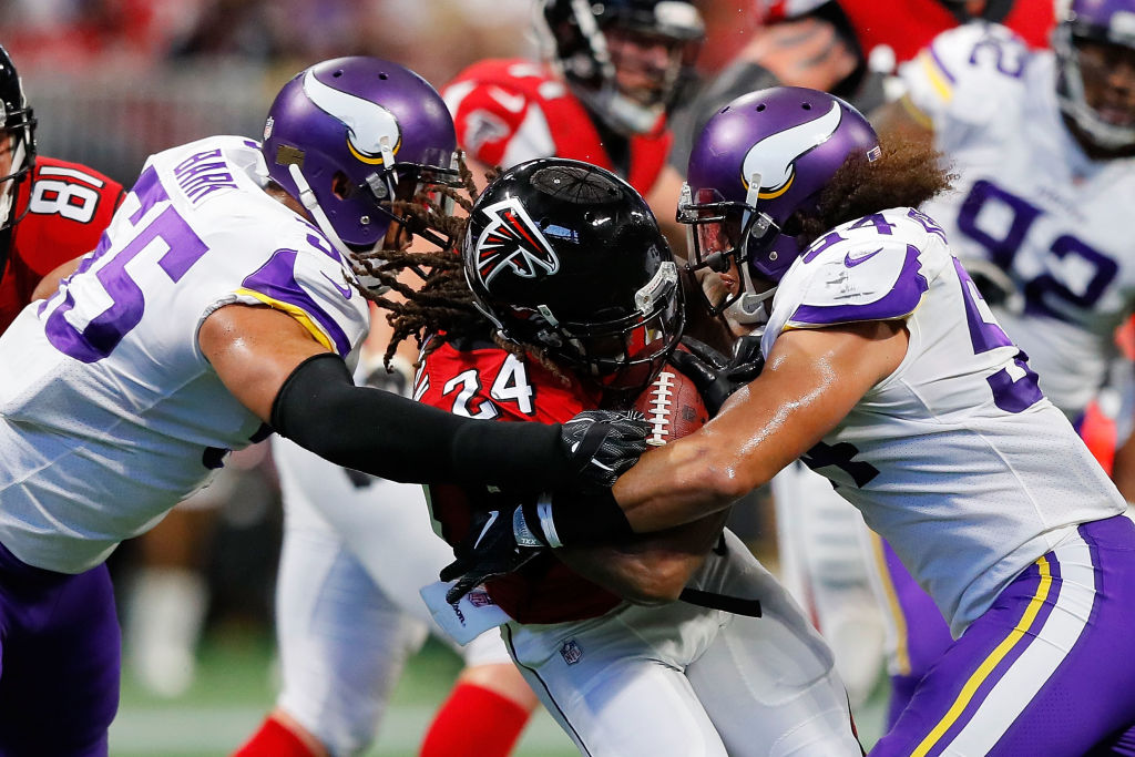 ATLANTA, GA - DECEMBER 03: Devonta Freeman #24 of the Atlanta Falcons is tackled by Eric Kendricks #54 and Anthony Barr #55 of the Minnesota Vikings during the first half at Mercedes-Benz Stadium on December 3, 2017 in Atlanta, Georgia.