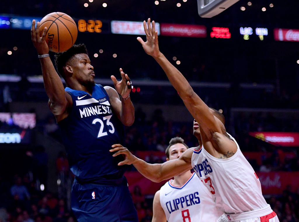 LOS ANGELES, CA - DECEMBER 06: Jimmy Butler #23 of the Minnesota Timberwolves passes around Wesley Johnson #33 and Danilo Gallinari #8 of the LA Clippers during the first half at Staples Center on December 6, 2017 in Los Angeles, California.