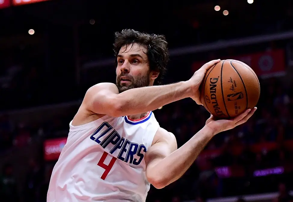 LOS ANGELES, CA - DECEMBER 20: Milos Teodosic #4 of the LA Clippers passes around Alan Williams #15 of the Phoenix Suns during the first half at Staples Center on December 20, 2017 in Los Angeles, California.