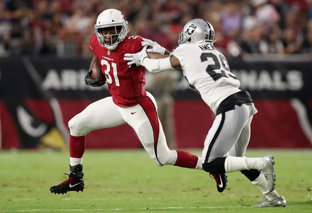 GLENDALE, AZ - AUGUST 12: Running back David Johnson #31 of the Arizona Cardinals rushes the football past cornerback David Amerson #29 of the Oakland Raiders during the NFL game at the University of Phoenix Stadium on August 12, 2017 in Glendale, Arizona. The Cardinals defeated the Raiders 20-10.