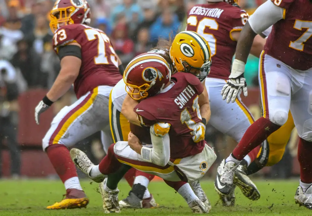 LANDOVER, MD - SEPTEMBER 23: Washington Redskins quarterback Alex Smith (11) is tackled by Green Bay Packers linebacker Clay Matthews (52) who was called for roughing the passer in the fourth quarter on September 23, 2018, at FedEx Field in Landover, MD. The Washington Redskins defeated the Green Bay Packers, 31-17