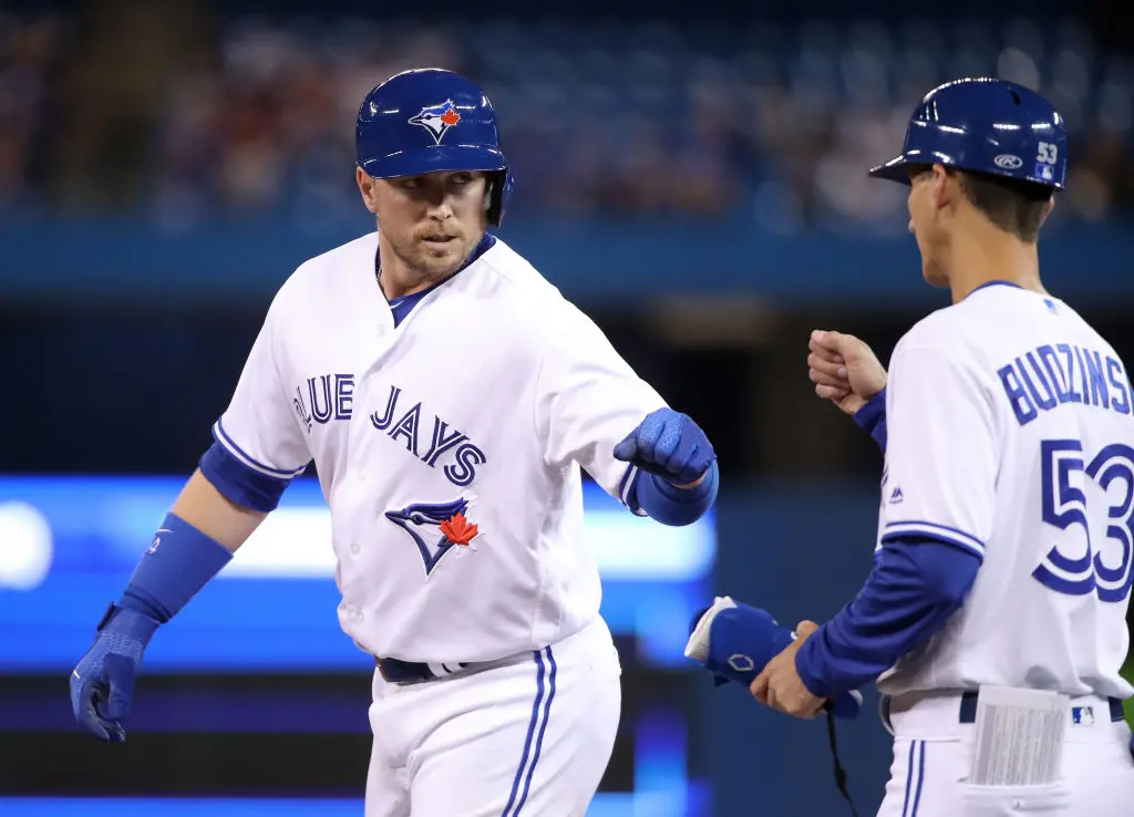 TORONTO, ON - MARCH 29: Justin Smoak #14 of the Toronto Blue Jays is congratulated by first base coach Mark Budzinski #53 after hitting a single in the fourth inning during MLB game action against the Detroit Tigers at Rogers Centre on March 29, 2019 in Toronto, Canada.