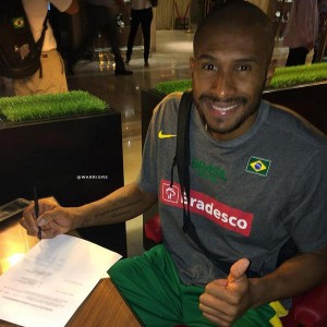 Leandrinho assinando contrato ainda na concentração do Brasil (Foto: Divulgação/Twitter)