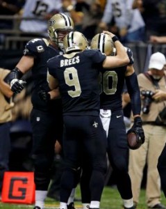 Drew Brees comemora com companheiros a vitória dos Saints, que embola a NFC South (Foto: AP)
