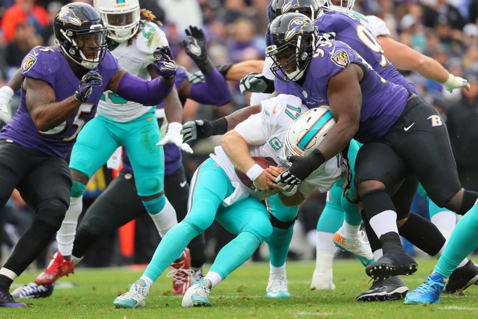 Defesa do Baltimore Ravens sacando o quarterback Ryan Tannehill na vitória sobre o Miami Dolphins na Semana 13 da NFL 2016