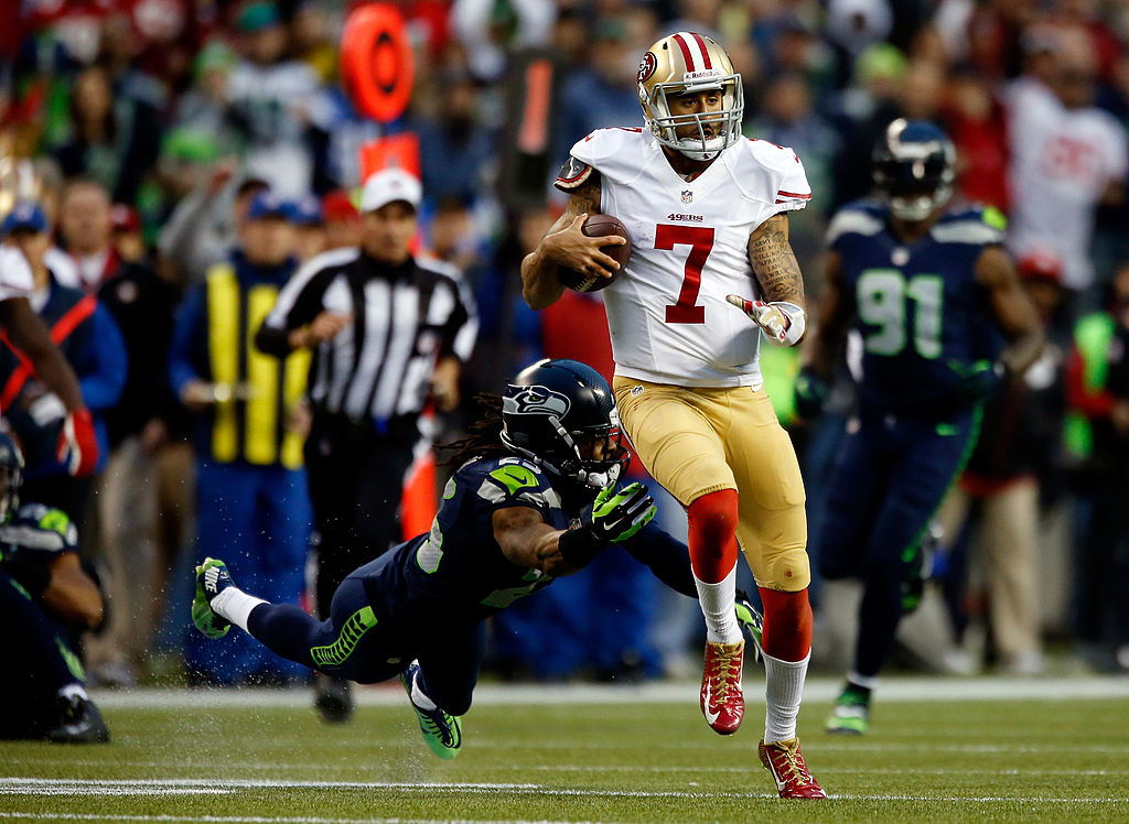 SEATTLE, WA - JANUARY 19: Quarterback Colin Kaepernick #7 of the San Francisco 49ers runs the ball as cornerback Richard Sherman #25 of the Seattle Seahawks attempts a tackle in the second quarter during the 2014 NFC Championship at CenturyLink Field on January 19, 2014 in Seattle, Washington.
