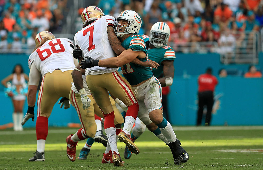 MIAMI GARDENS, FL - NOVEMBER 27: Kiko Alonso #47 of the Miami Dolphins hits Colin Kaepernick #7 of the San Francisco 49ers after a pass during a game on November 27, 2016 in Miami Gardens, Florida.