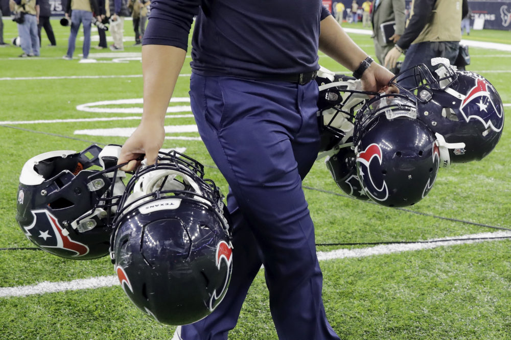 HOUSTON, TX - JANUARY 07: A Houston Texans equipment manager carries helmets after the game against the Oakland Raiders at NRG Stadium on January 7, 2017 in Houston, Texas.
