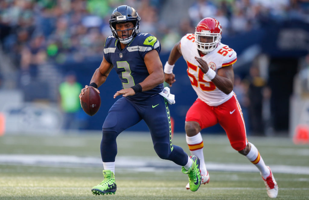 SEATTLE, WA - AUGUST 25: Quarterback Russell Wilson #3 of the Seattle Seahawks rushes under pressure from linebacker Dee Ford #55 of the Kansas City Chiefs at CenturyLink Field on August 25, 2017 in Seattle, Washington.
