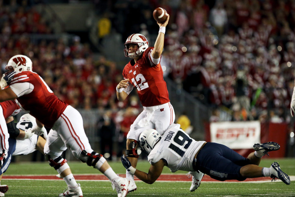 MADISON, WI - SEPTEMBER 01: Alex Hornibrook #12 of the Wisconsin Badgers throws a pass while being hit by Ian Togiai #19 of the Utah State Aggies in the second quarter at Camp Randall Stadium on September 1, 2017 in Madison, Wisconsin.