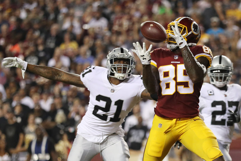 LANDOVER, MD - SEPTEMBER 24: Tight end Vernon Davis #85 of the Washington Redskins scores a touchdown in the second quarter as cornerback Sean Smith #21 of the Oakland Raiders tries to stop him at FedExField on September 4, 2017 in Landover, Maryland.
