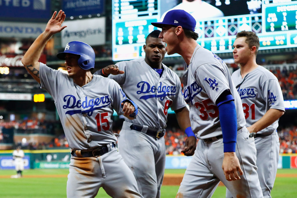 HOUSTON, TX - OCTOBER 29: Austin Barnes #15 of the Los Angeles Dodgers celebrates with Yasiel Puig #66, Cody Bellinger #35 and Joc Pederson #31 after scoring on a single during the ninth inning against the Houston Astros in game five of the 2017 World Series at Minute Maid Park on October 29, 2017 in Houston, Texas.
