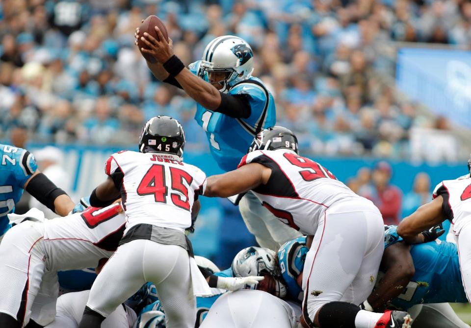 Cam Newton pula por cima da linha defensiva para conquistar o first down na vitória do Carolina Panthers contra o Atlanta Falcons na Semana 9 da NFL.