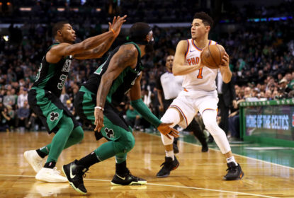 BOSTON, MA - DECEMBER 2: Kyrie Irving #11 of the Boston Celtics and Marcus Smart #36 defend Devin Booker #1 of the Phoenix Suns during the second half at TD Garden on December 2, 2017 in Boston, Massachusetts. The Celtics defeat the Suns 116-111.