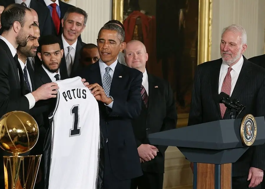 WASHINGTON, DC - JANUARY 12: U.S. President Barack Obama is given a jersey by player Manu Ginobili during an event to honor the 2014 NBA Champion San Antonio Spurs in the East Room at the White House, January 12, 2015 in Washington, DC. President Obama honored the Spurs for winning their fifth NBA championship by beating the Miami Heat in game five with a 104-87 victory.