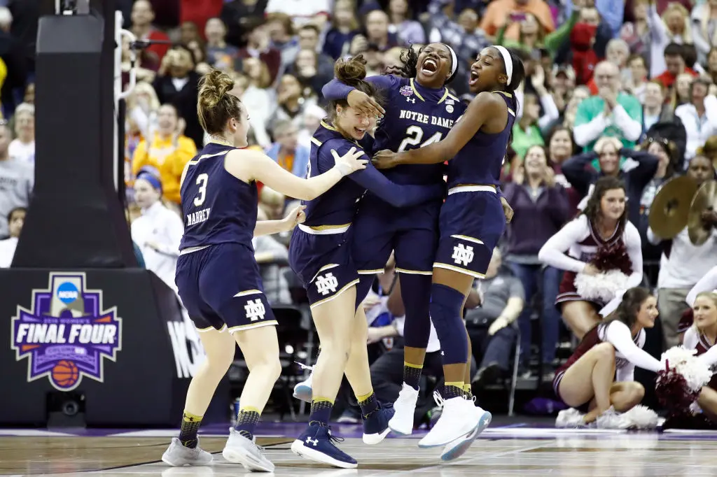 COLUMBUS, OH - APRIL 01: Arike Ogunbowale #24 of the Notre Dame Fighting Irish is congratulated by her teammates Marina Mabrey #3, Kathryn Westbeld #33 and Jackie Young #5 after scoring the game winning basket with 0.1 seconds remaining in the fourth quarter to defeat the Mississippi State Lady Bulldogs in the championship game of the 2018 NCAA Women's Final Four at Nationwide Arena on April 1, 2018 in Columbus, Ohio. The Notre Dame Fighting Irish defeated the Mississippi State Lady Bulldogs 61-58.
