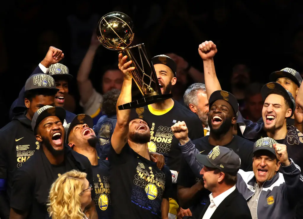 Stephen Curry #30 of the Golden State Warriors celebrates with the Larry O'Brien Trophy after defeating the Cleveland Cavaliers during Game Four of the 2018 NBA Finals