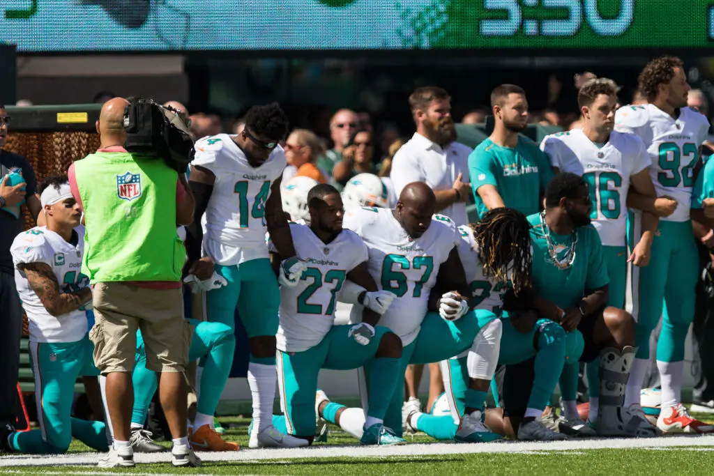 EAST RUTHERFORD, NJ - SEPTEMBER 24: Several of the Miami Dolphins take a knee during the National Anthem prior to the start of a regular season NFL game between the Miami Dolphins and the New York Jets on September 24, 2017, at MetLife Stadium in East Rutherford, NJ