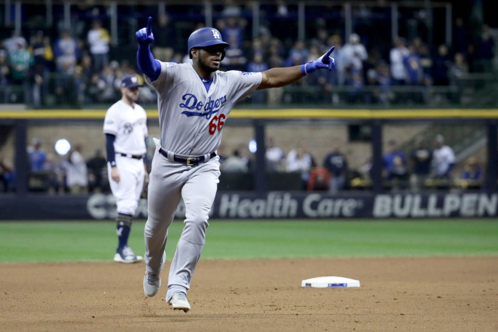 MILWAUKEE, WI - OCTOBER 20: Yasiel Puig #66 of the Los Angeles Dodgers celebrates after hitting a three run home run against Jeremy Jeffress #32 of the Milwaukee Brewers during the sixth inning in Game Seven of the National League Championship Series at Miller Park on October 20, 2018 in Milwaukee, Wisconsin