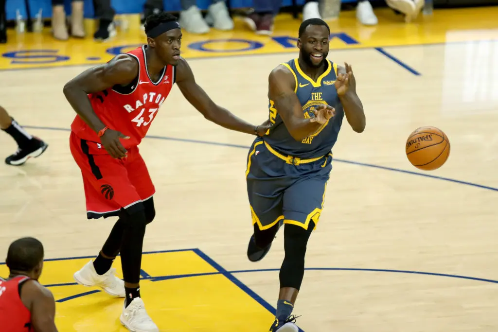 OAKLAND, CALIFORNIA - DECEMBER 12: Golden State Warriors' Draymond Green (23) passes the ball against Toronto Raptors' Pascal Siakam (43) during the second quarter of a NBA game at Oracle Arena in Oakland