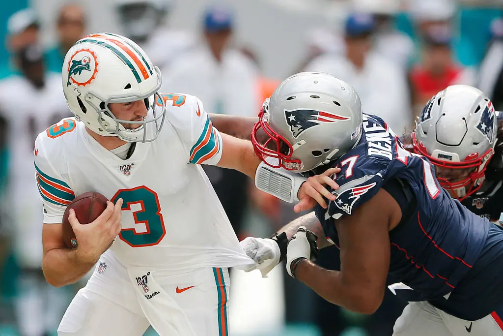 MIAMI, FLORIDA - SEPTEMBER 15: Josh Rosen #3 of the Miami Dolphins is sacked by Michael Bennett #77 of the New England Patriots during the fourth quarter at Hard Rock Stadium on September 15, 2019 in Miami, Florida