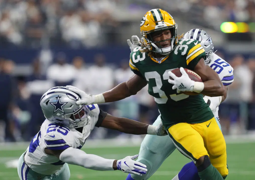 ARLINGTON, TEXAS - OCTOBER 06: Aaron Jones #33 of the Green Bay Packers stiff-arms Xavier Woods #25 of the Dallas Cowboys on a run in the first quarter at AT&T Stadium on October 06, 2019 in Arlington, Texas