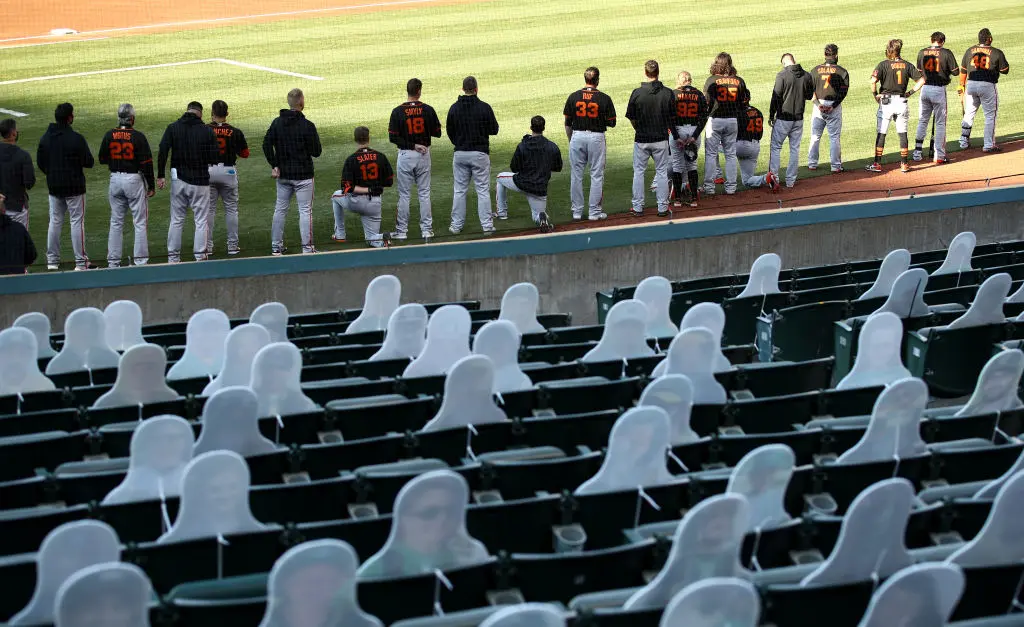 OAKLAND, CALIFORNIA - JULY 20: Austin Slater #13 and Jaylin Davis #49 of the San Francisco Giants kneel during the National Anthem before their exhibition game against the Oakland Athletics at Oakland-Alameda County Coliseum on July 20, 2020 in Oakland, California