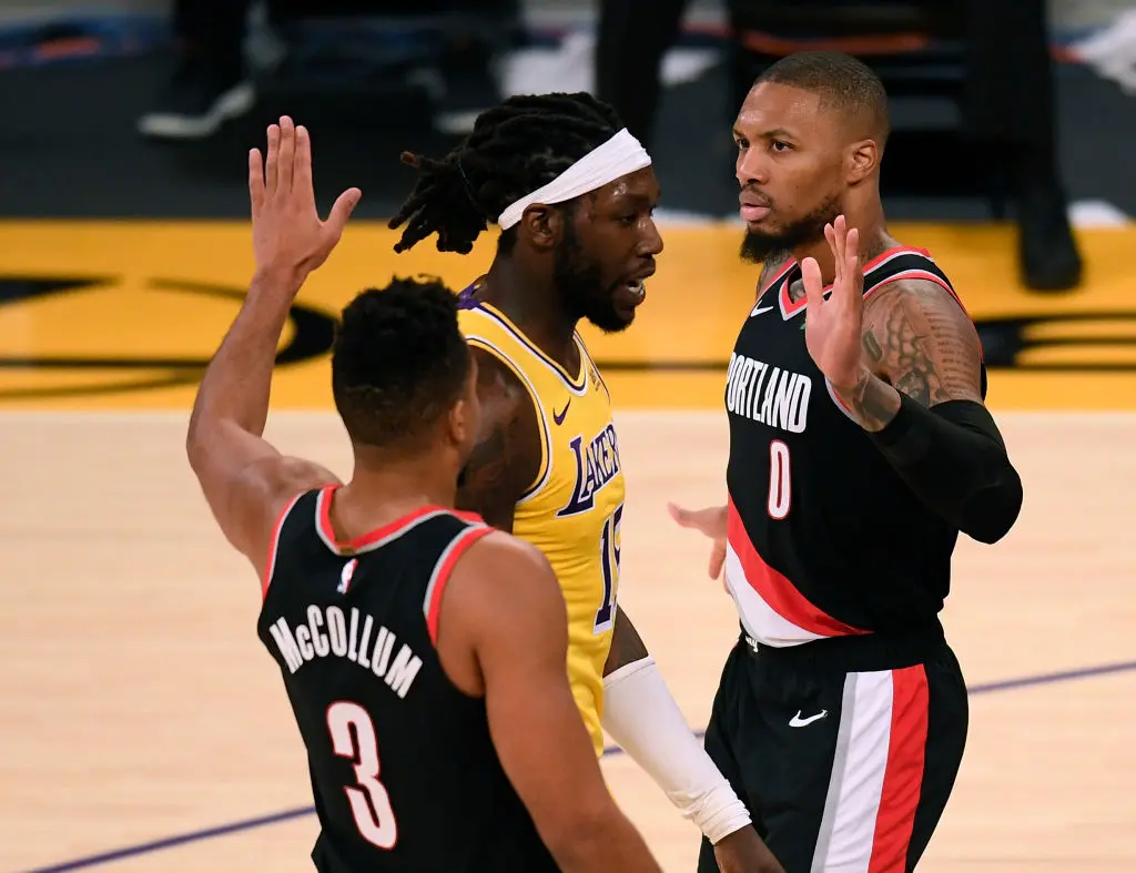 LOS ANGELES, CALIFORNIA - DECEMBER 28: Damian Lillard #0 of the Portland Trail Blazers celebrates his basket with a foul with CJ McCollum #3, as Montrezl Harrell #15 of the Los Angeles Lakers reacts, during a 115-107 Trail Blaizer win at Staples Center on December 28, 2020 in Los Angeles, California
