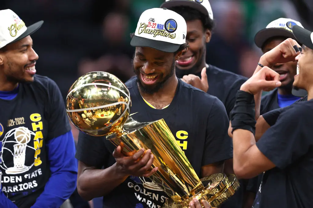 Troféu - BOSTON, MASSACHUSETTS - JUNE 16: Andrew Wiggins #22 of the Golden State Warriors celebrates with th Larry O'Brien Championship Trophy after defeating the Boston Celtics 103-90 in Game Six of the 2022 NBA Finals at TD Garden on June 16, 2022 in Boston, Massachusetts.