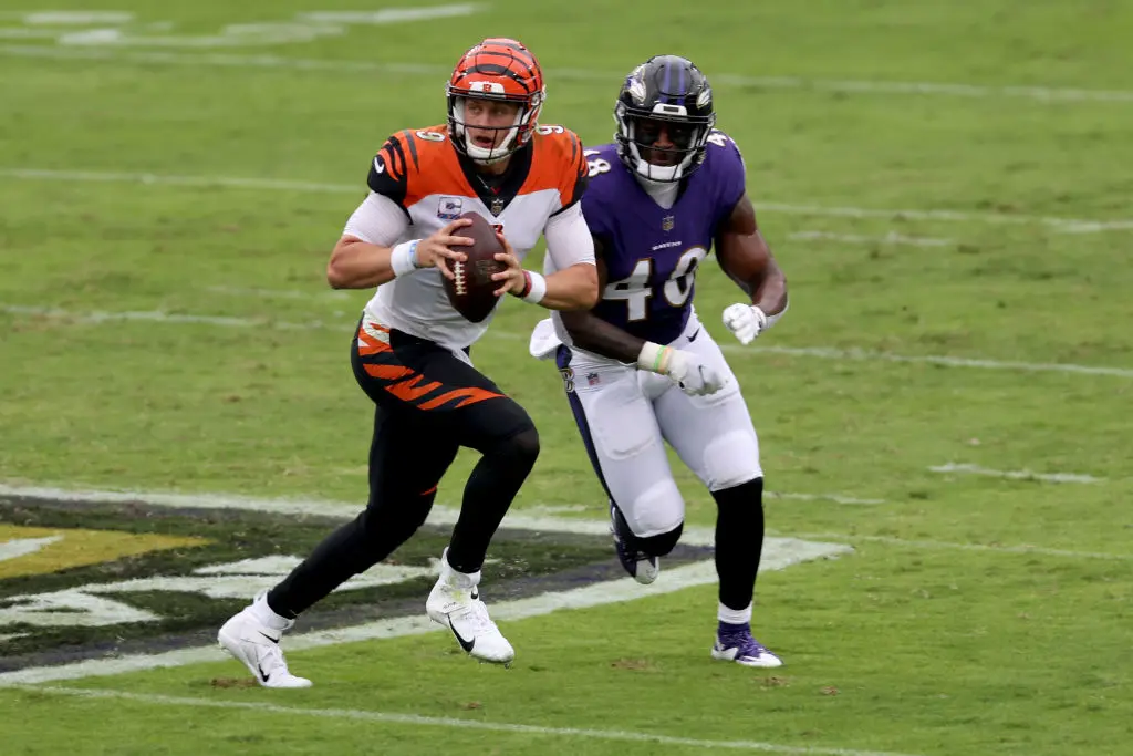 BALTIMORE, MARYLAND - OCTOBER 11: Quarterback Joe Burrow #9 of the Cincinnati Bengals is chased by inside linebacker Patrick Queen #48 of the Baltimore Ravens in the first half at M&T Bank Stadium on October 11, 2020 in Baltimore, Maryland