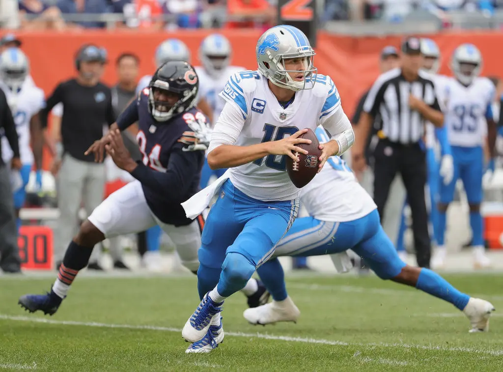CHICAGO, ILLINOIS - OCTOBER 03: Jared Goff #16 of the Detroit Lions rolls out to look for a receiver as Robert Quinn #94 of the Chicago Bears rushes behind him at Soldier Field on October 03, 2021 in Chicago, Illinois. The Bears defeated the Lions 24-14