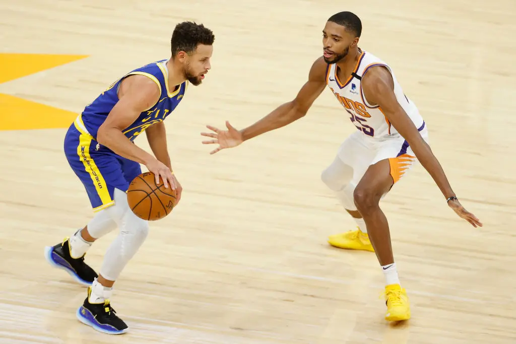 PHOENIX, ARIZONA - JANUARY 28: Stephen Curry #30 of the Golden State Warriors handles the ball against Mikal Bridges #25 of the Phoenix Suns during the NBA game at Phoenix Suns Arena on January 28, 2021 in Phoenix, Arizona
