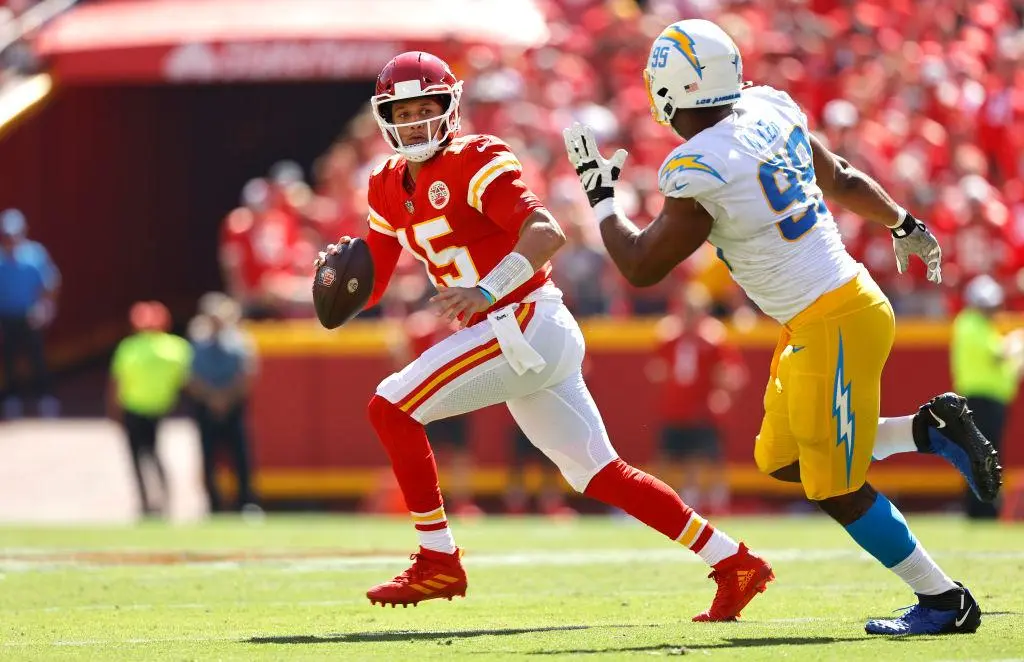 KANSAS CITY, MISSOURI - SEPTEMBER 26: Patrick Mahomes #15 of the Kansas City Chiefs scrambles and looks to avoid a sack by Jerry Tillery #99 of the Los Angeles Chargers during the first half in the game at Arrowhead Stadium on September 26, 2021 in Kansas City, Missouri