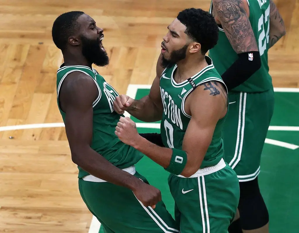 BOSTON - DECEMBER 23: Boston Celtics' Jayson Tatum, right, is chest bumped by teammate Jaylen Brown after Tatum hit a three point shot that won the game. The Boston Celtics host the Milwaukee Bucks in the opening game of the NBA regular season at the TD Garden in Boston on Dec. 23, 2020.