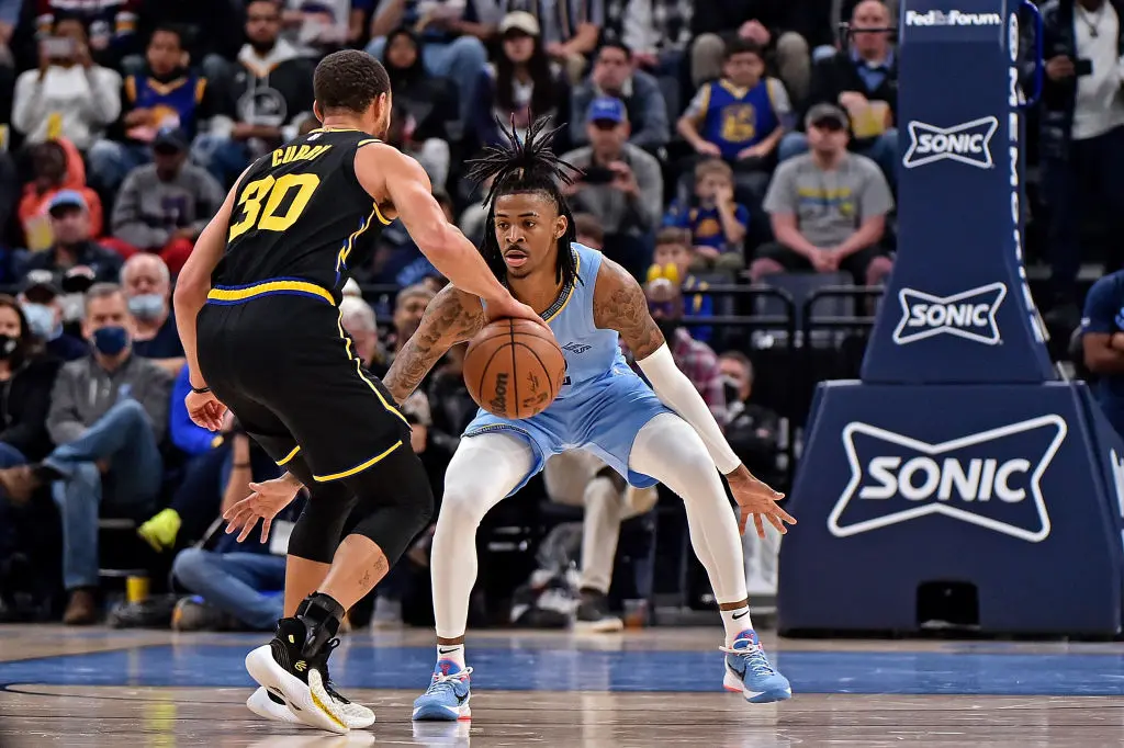 MEMPHIS, TENNESSEE - JANUARY 11: Ja Morant #12 of the Memphis Grizzlies guards Stephen Curry #30 of the Golden State Warriors during the second half at FedExForum on January 11, 2022 in Memphis, Tennessee.