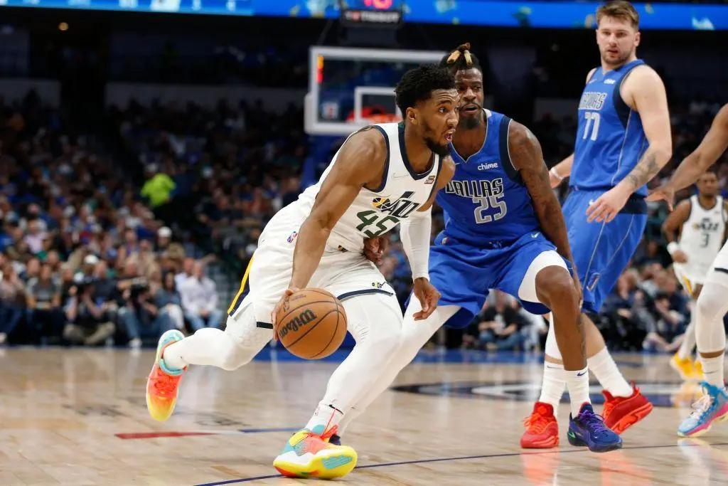 DALLAS, TEXAS - MARCH 27: Donovan Mitchell #45 of the Utah Jazz drives to the basket against Reggie Bullock #25 of the Dallas Mavericks at American Airlines Center on March 27, 2022 in Dallas, Texas.