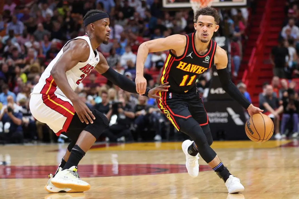 MIAMI, FLORIDA - APRIL 08: Trae Young #11 of the Atlanta Hawks dribbles against Jimmy Butler #22 of the Miami Heat during the first half at FTX Arena on April 08, 2022 in Miami, Florida.