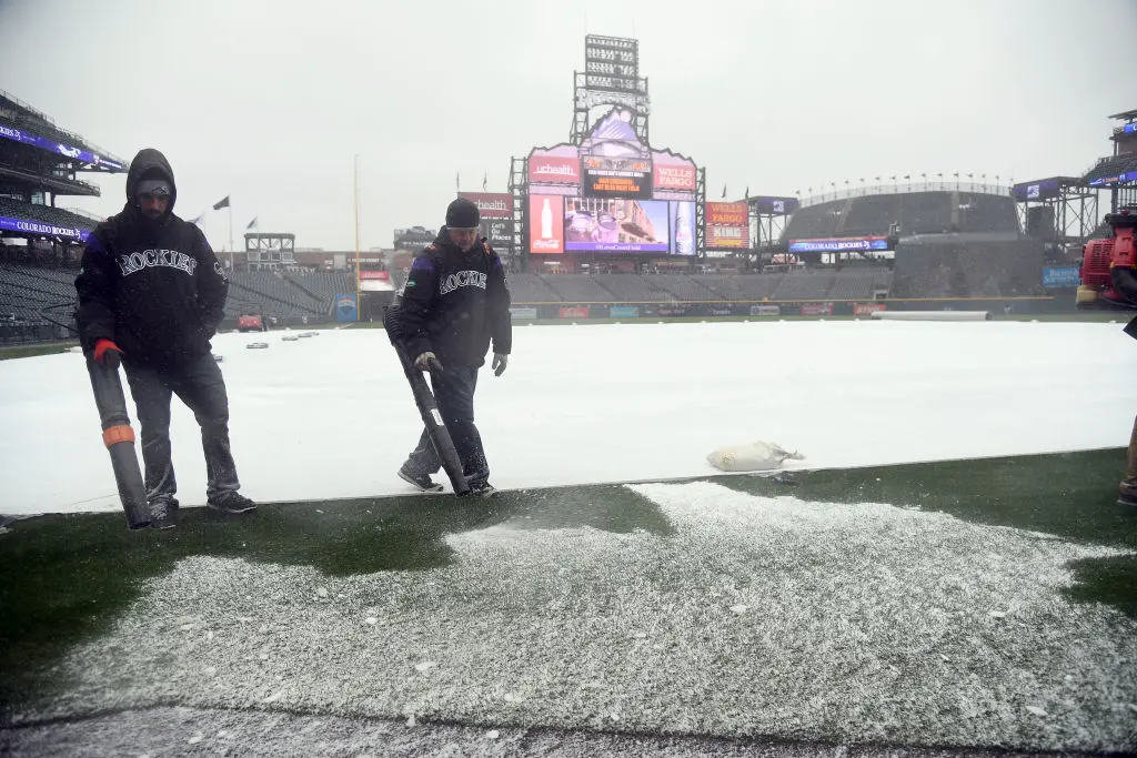 DENVER, CO - APRIL 6: Colorado Rockies grounds crew use leaf blowers to blow off the snow around the edges of the field on Opening Day against the Atlanta Braves on April 6, 2018 Coors Field in Denver, Colorado