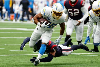 HOUSTON, TEXAS - OCTOBER 02: Austin Ekeler #30 of the Los Angeles Chargers runs with the ball while being chased by Jalen Pitre #5 of the Houston Texans in the second quarter at NRG Stadium on October 02, 2022 in Houston, Texas