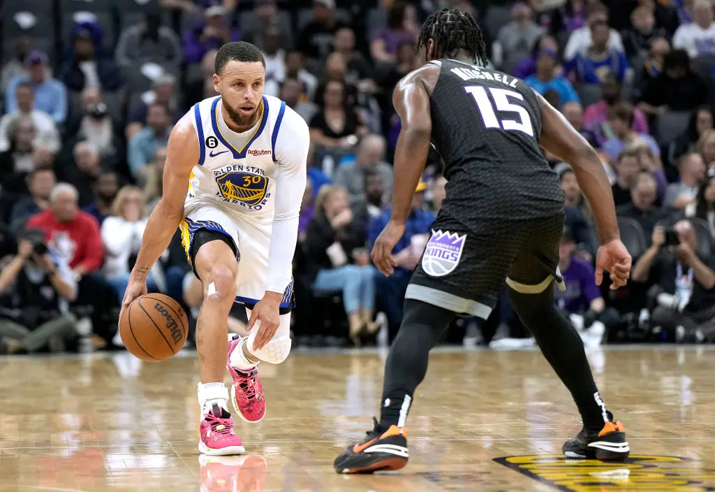 SACRAMENTO, CALIFORNIA - APRIL 07: Stephen Curry #30 of the Golden State Warriors dribbles the ball up court while defended by Davion Mitchell #15 of the Sacramento Kings during the second quarter at Golden 1 Center on April 07, 2023 in Sacramento, California.