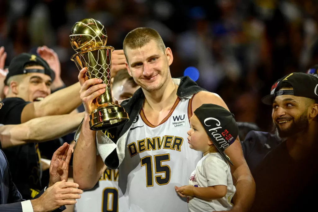 DENVER, CO - JUNE 12: Nikola Jokic (15) of the Denver Nuggets displays the NBA Finals Most Valuable Player Award as the star holds his daughter, Ognjena, after the fourth quarter of the Nuggets' 94-89 NBA Finals clinching win over the Miami Heat at Ball Arena in Denver on Monday, June 12, 2023.