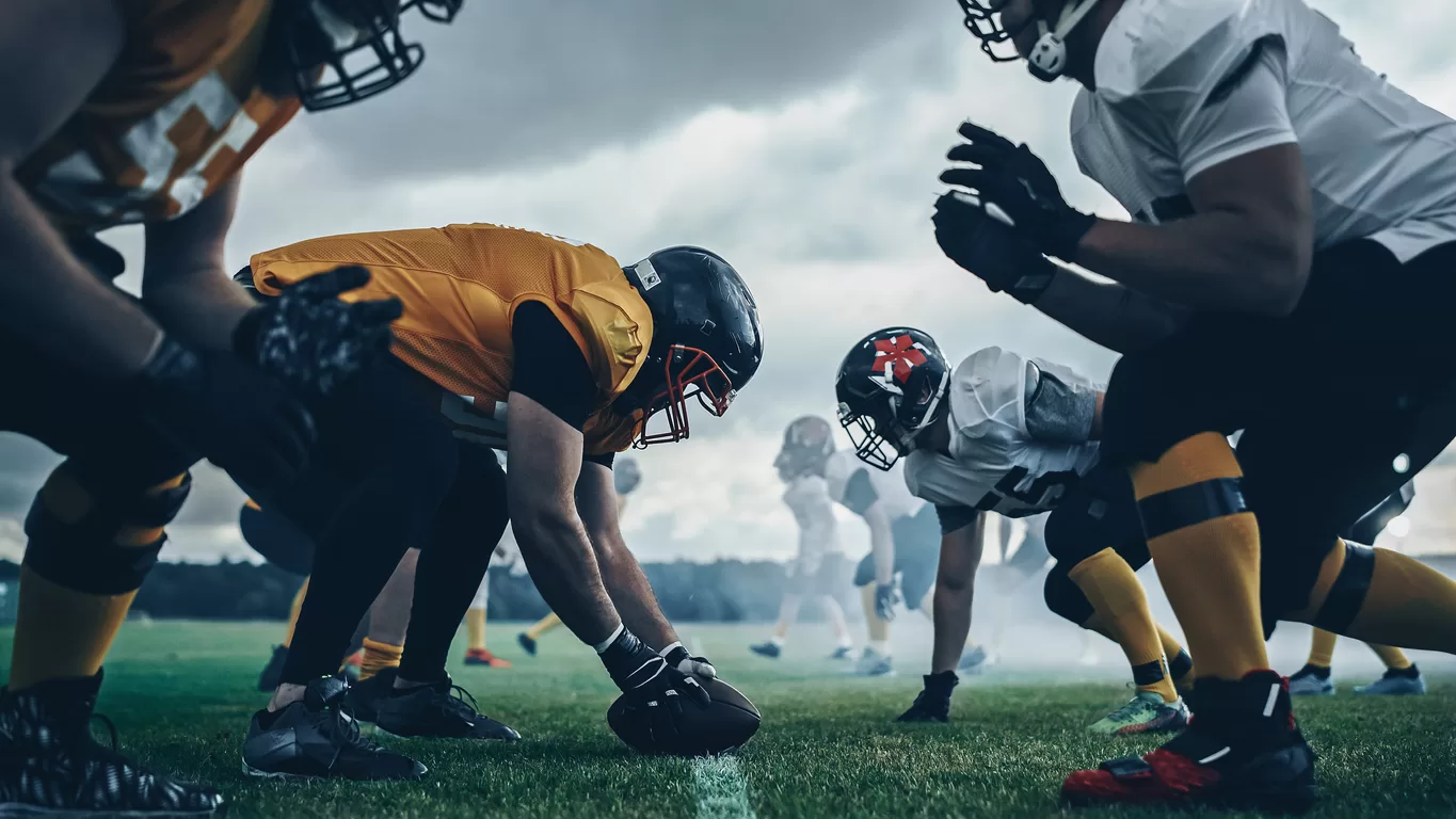 American Football Championship. Teams Ready: Professional Players, Aggressive Face-off, Ready for Pushing, Tackling. Competition Full of Brutal Energy, Power. Shot with Dramatic Light