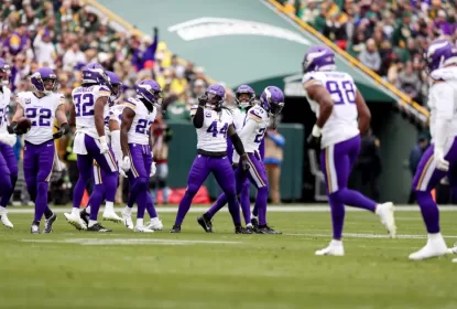 Jogadores do Minnesota Vikings comemorando após interceptação de Jordan Love
