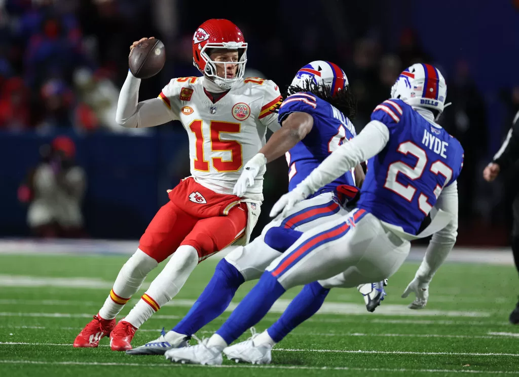 ORCHARD PARK, NEW YORK - JANUARY 21: Patrick Mahomes #15 of the Kansas City Chiefs dodges Micah Hyde #23 of the Buffalo Bills during their AFC Divisional Playoff game at Highmark Stadium on January 21, 2024 in Orchard Park, New York.